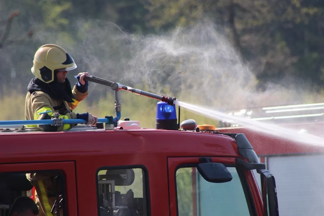 Firefighter spraying water from the roof of a fire engine