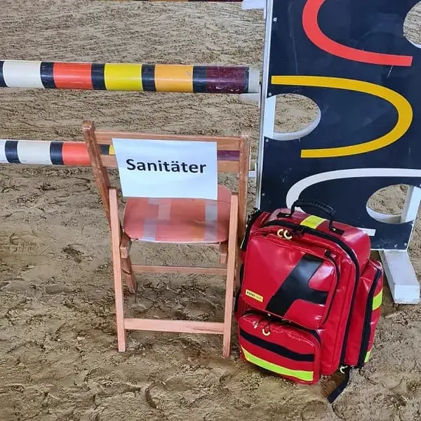 Medic station with a red emergency backpack by the course in an indoor riding arena